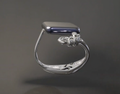 Silver ring with a blue gemstone on a dark gray background